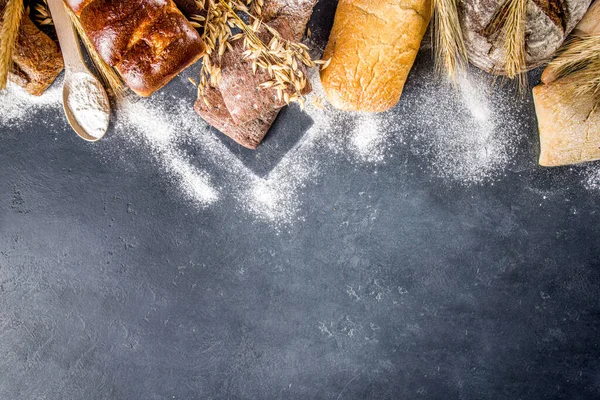 Çeşitli ekmek setleri. Birçok farklı buğday, tahıl ve çavdar ekmeği çavdar ve buğday, un ve fırıncı aletleriyle beyaz ahşap arka planda.