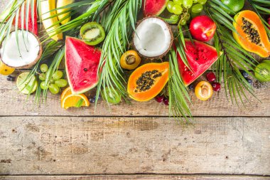 Farklı tropik taze meyve ve böğürtlen çeşitleri. Temiz yemek, sağlıklı yaşam tarzı, diyet ve vitamin konsepti. Üst görünüm düz tahta masa arkaplanı