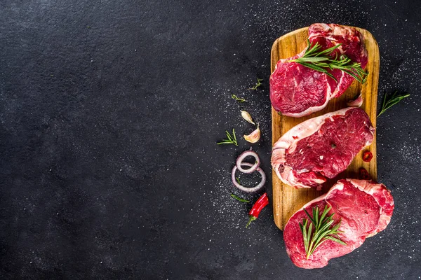 Syrové Maso Hovězí Steak Řezací Desce Rozmarýnem Kořením Černé Pozadí — Stock fotografie