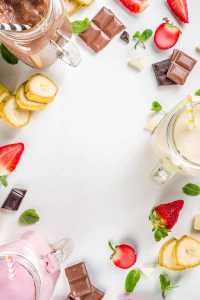 ミルクセーキまたはスムージーと3つのメイソン瓶 夏の健康的な朝食 ランチドリンク 木製の背景にバナナ チョコレート ストロベリーミルクシェーク — ストック写真
