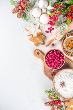 Noel yemeği, kış kurabiyesi, zencefilli çörek, meyveli kek, mevsimlik içecekler. Kızılcıklar, kurutulmuş portakallar, tarçın, baharatlar, beyaz masaya un, uzay manzarasını kopyala