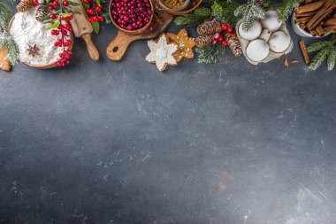 Noel yemeği, kış kurabiyesi, zencefilli çörek, meyveli kek, mevsimlik içecekler. Kızılcıklar, kurutulmuş portakallar, tarçın, baharatlar, koyu taş masadaki un, uzay manzarasını kopyala