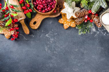 Noel yemeği, kış kurabiyesi, zencefilli çörek, meyveli kek, mevsimlik içecekler. Kızılcıklar, kurutulmuş portakallar, tarçın, baharatlar, koyu taş masadaki un, uzay manzarasını kopyala