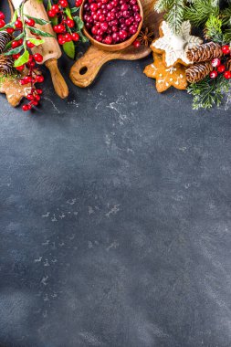 Noel yemeği, kış kurabiyesi, zencefilli çörek, meyveli kek, mevsimlik içecekler. Kızılcıklar, kurutulmuş portakallar, tarçın, baharatlar, koyu taş masadaki un, uzay manzarasını kopyala