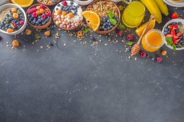Çeşitli kahvaltı yemekleri konsepti. Geleneksel sağlıklı kahvaltı yemekleri ve içecekler - yulaf, granola, yoğurt, smoothie bowl, tost, mısır gevreği, kruvasan, kahve ve çay fincanı, portakal suyu, meyve, böğürtlen