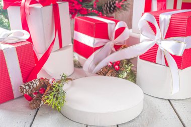 Mutlu Noeller ve mutlu yıllar. Noel tebrik kartı geçmişi. Noel hediyesi kutuları, renkli beyaz podyumlar, ürününüz için yer, ahşap arka plan.