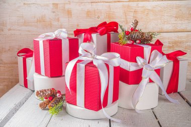 Mutlu Noeller ve mutlu yıllar. Noel tebrik kartı geçmişi. Noel hediyesi kutuları, renkli beyaz podyumlar, ürününüz için yer, ahşap arka plan.
