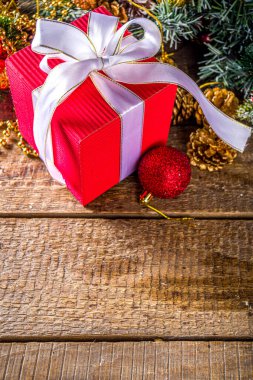 Noel tebrik kartı geçmişi. Kurdeleli büyük noel hediyesi kutusu, iyon şenlikli Xmas masası, dekorasyon ve oyuncaklarla, kar efekti arka plan kopyalama alanı