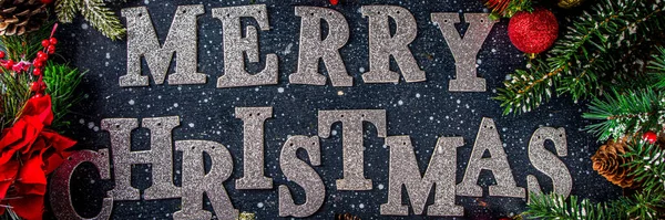 Christmas background with lettering Merry Christmas. Festive inscription Merry Christmas over dark blue table with xmas decoration