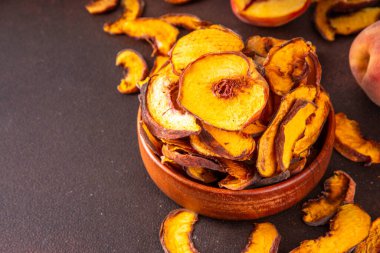 Ev yapımı güneş sublimleşmiş şeftali dilimleri, sağlıklı tatlı yiyecekler, meyve cipsi, yemek ve tatlı için malzemeler. Şekersiz alternatif koruma