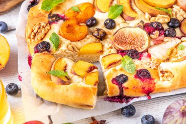 Lezzetli meyve tatlısı Focaccia. Tatlı viral italyan Focaccia açık turtası, çeşitli mevsimlik sonbahar ve yaz meyveleriyle - erik, elma, incir, kayısı, yabanmersini, şeftali ve fındık, baharat ve bal ile