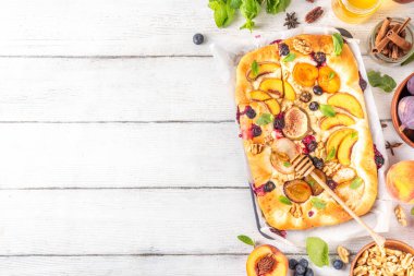 Lezzetli meyve tatlısı Focaccia. Tatlı viral italyan Focaccia açık turtası, çeşitli mevsimlik sonbahar ve yaz meyveleriyle - erik, elma, incir, kayısı, yabanmersini, şeftali ve fındık, baharat ve bal ile