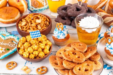 Oktoberfest festival yemekleri, çeşitli atıştırmalıklar, tatlılar, tatlılar, krakerler, bira jölesi, zencefilli kurabiye kalpleri, tuzlanmış krakerler, patlamış mısır, reçelli çörekler, kekler. Oktoberfest brunch menüsü arkaplanı