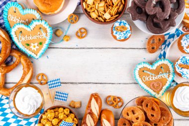 Oktoberfest festival yemekleri, çeşitli atıştırmalıklar, tatlılar, tatlılar, krakerler, bira jölesi, zencefilli kurabiye kalpleri, tuzlanmış krakerler, patlamış mısır, reçelli çörekler, kekler. Oktoberfest brunch menüsü arkaplanı