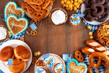 Oktoberfest festival yemekleri, çeşitli atıştırmalıklar, tatlılar, tatlılar, krakerler, bira jölesi, zencefilli kurabiye kalpleri, tuzlanmış krakerler, patlamış mısır, reçelli çörekler, kekler. Oktoberfest brunch menüsü arkaplanı