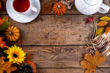 Sonbahar mevsiminde sıcak kahvaltı, bahçede erken sonbahar çayı, balkabağı mumları ve dekorlu taze demlenmiş çay fincanı, sonbahar yaprakları ve açık kitap, okuma zamanı sakin hayat