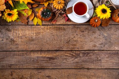 Sonbahar mevsiminde sıcak kahvaltı, bahçede erken sonbahar çayı, balkabağı mumları ve dekorlu taze demlenmiş çay fincanı, sonbahar yaprakları ve açık kitap, okuma zamanı sakin hayat