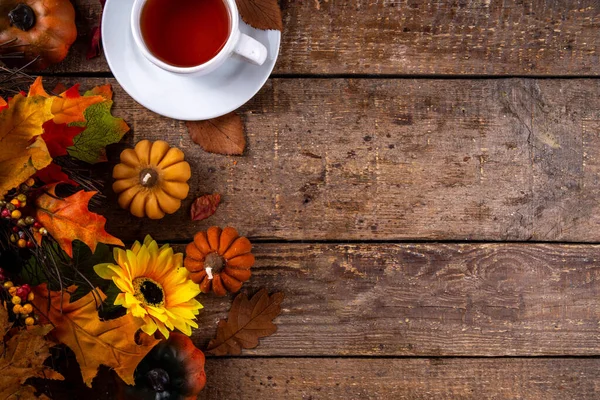 Sonbahar mevsiminde sıcak kahvaltı, bahçede erken sonbahar çayı, balkabağı mumları ve dekorlu taze demlenmiş çay fincanı, sonbahar yaprakları ve açık kitap, okuma zamanı sakin hayat