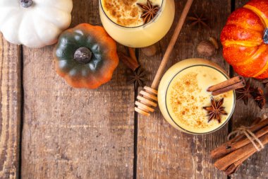 Sonbahar içkisi, balkabağı baharatlı eggnog kokteyli, bal, tarçın çubukları ve anason yıldızları, lezzetli tatlı mevsimi içeceği 