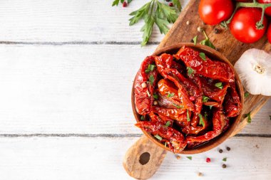 Zeytin yağında ev yapımı kurutulmuş domatesler, gurme İtalyan yemekleri, taze domates, yağ şişesi ve mutfak masasında baharatlar.