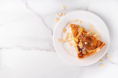 Geleneksel Fransız badem keki, kayısı, kokulu karamelli tatlı meyve turtası badem yaprakları ve pudra şekeri.