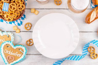 Oktoberfest tebrik kartı geçmişinde iki bira bardağı, tuzlu atıştırmalık ve kraker var. Oktoberfest barı, beyaz ahşap masa üzerindeki kafe menüsü, Ekim Festivali tarzı kareli peçete ve dekorla