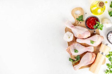 Tavuk eti hazırlama arka planı, ızgaraya hazır çiğ tavuk bacağı, baharatlar, tuz, biber, zeytinyağı, sarımsak ve salamura veya sos. Izgara ve bbq sezon pişirme arka planı, kopyalama alanı