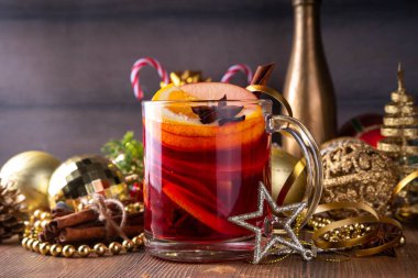 Tatlı elma, portakal, bal, tarçın ve anason yıldızlı cam bardak, ahşap masa üzerinde Noel süsü, tatil içkisi. Sıcak baharatlı amber çayı, alkolsüz sıcak içecek.