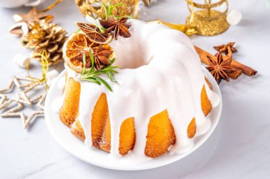 Noel pastası şekerli, portakallı ve biberiyeli. Geleneksel Noel ve yeni yıl pişirilmiş tatlı, vanilyalı meyveli kek, beyaz xmas süslemeli arka plan