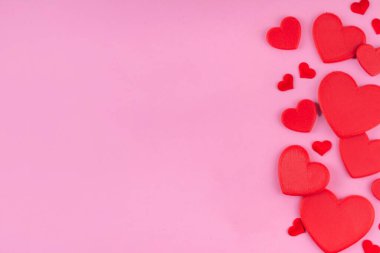 Sevgililer günü pembe arka planı, kırmızı kalpler, çeşitli kırmızı kalpler pastel pembe arka plan üzerinde basit bir düzen, üst görünüm kopyalama alanı. Sevgililer günü davetiyesi, menü, tebrik kartı. 