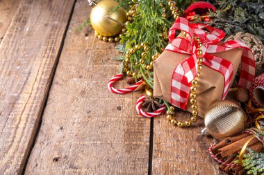 Noel arkaplanı hediye kutusu, köknar ağacı ve takılar, Noel ve yeni yıl tebrik kartı veya davetiyesi için bayram ağacı ahşap arka planı, kopyalama alanı