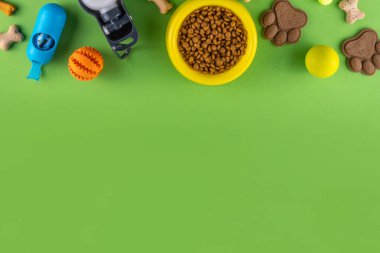 Parlak arka planda köpek ve kedi için yiyecek, atıştırmalık, oyuncak ve aksesuarlı düz bir kompozisyon vardı. Hayvan bakımı, köpek alışverişi ve satış konsepti. Üst görünüm kopya alanı