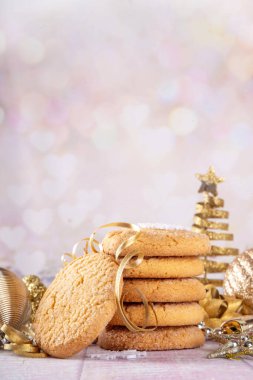 Noel arkaplanında geleneksel Amerikan şekerli kurabiyeler, altın takılar, Noel ağacı ve bokeh etkisi, kopyalama alanı