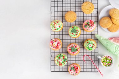 Noel süslemeli kurabiyeler. Lezzetli Amerikan kurabiyeleri. Yeşil ve kırmızı kremalı kopyacı. Üstüne de Noel şekeri süslemeleri.