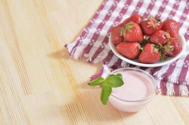 Ahşap bir masa üzerinde duran bir daire üzerinde kırmızı çilek