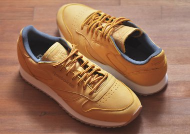 Kiev, Ukrayna - 30 Mayıs 2018: iki portakal Reebok spor ayakkabı ahşap arka plan üzerinde