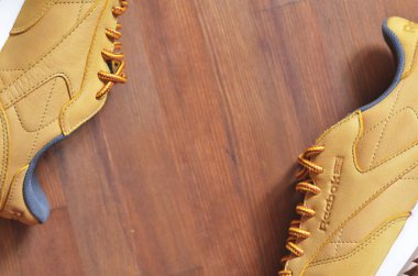 Kiev, Ukrayna - 30 Mayıs 2018: Reebok kahverengi spor ayakkabıları ahşap arka planda yatıyor