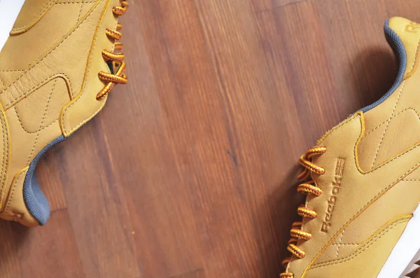 Kiev, Ukrayna - 30 Mayıs 2018: Reebok kahverengi spor ayakkabıları ahşap arka planda yatıyor