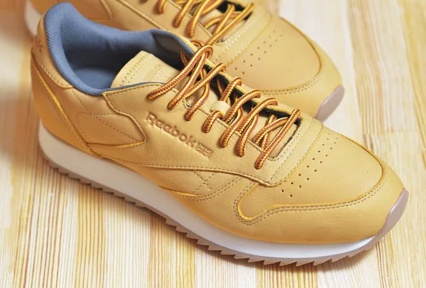 Kiev, Ukrayna - 30 Mayıs 2018: Reebok iki güzel erkekler kahverengi spor ayakkabıları bir ışık ahşap arka plan üzerinde durmak