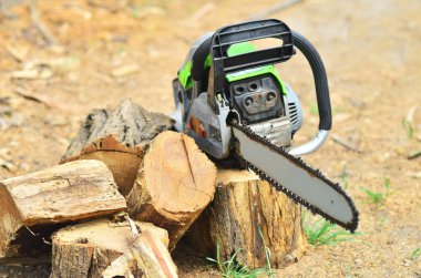 Büyük çalışma chainsaw güdük kıyılmış yakacak odun yanında yatıyor