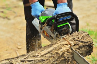 Erkekler eller eldiven bir chainsaw tutun, büyük bir günlük gördüm