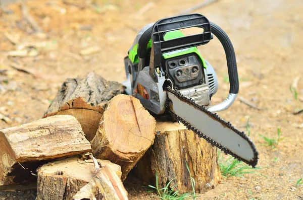 Büyük çalışma chainsaw güdük kıyılmış yakacak odun yanında yatıyor