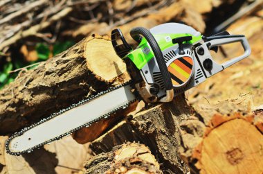 Büyük bir taze günlük yakınındaki bir güdük dışlanan chainsaw yatıyor