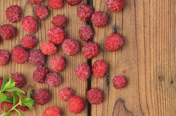 Ahududu meyveleri ahşap bir arka plan üzerinde nane fışkın dağılmış