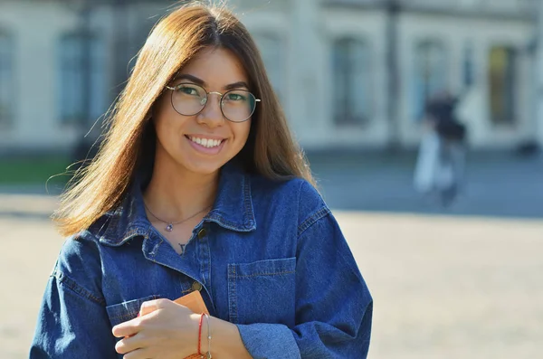 Retrato Chica Universitaria Sosteniendo Libros Con Estudiantes Borrosos Pie Parque —  Fotos de Stock