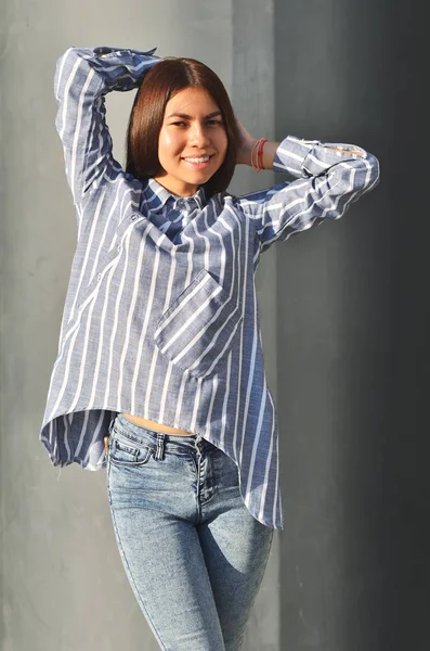 Joven asiática chica de moda posando cerca de negro la pared y está ordenando el día soleado —  Fotos de Stock