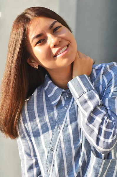 Ritratto giovane cool ragazza asiatica si trova vicino al muro e posa e ha vestito una camicia a righe — Foto Stock