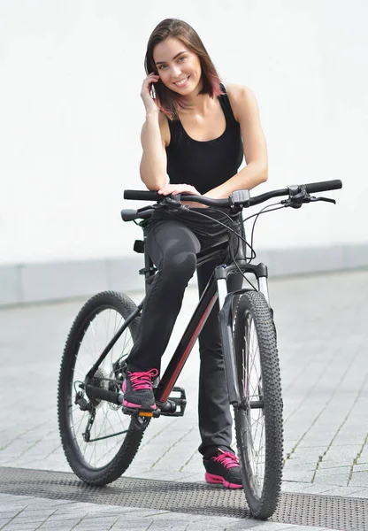 Gülümseyen güzel genç kız st üzerinde bisikleti ile ayakta — Stok fotoğraf