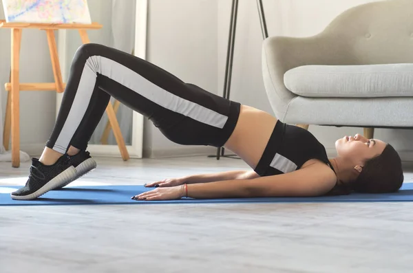 Siyah spor giyimli Asyalı güzel fitness kızı şınav çekiyor.