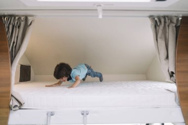 Karavan yatakta oynarken küçük çocuk